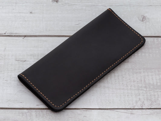 Close-up of a brown leather bifold wallet showing the smooth, sealed edge finish